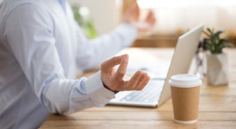 Man meditating at laptop