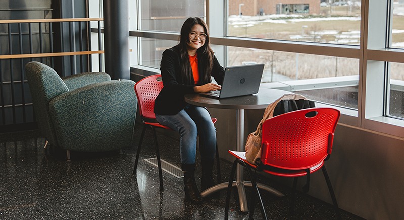 Image of Normandale student with laptop taking community college classes for adults