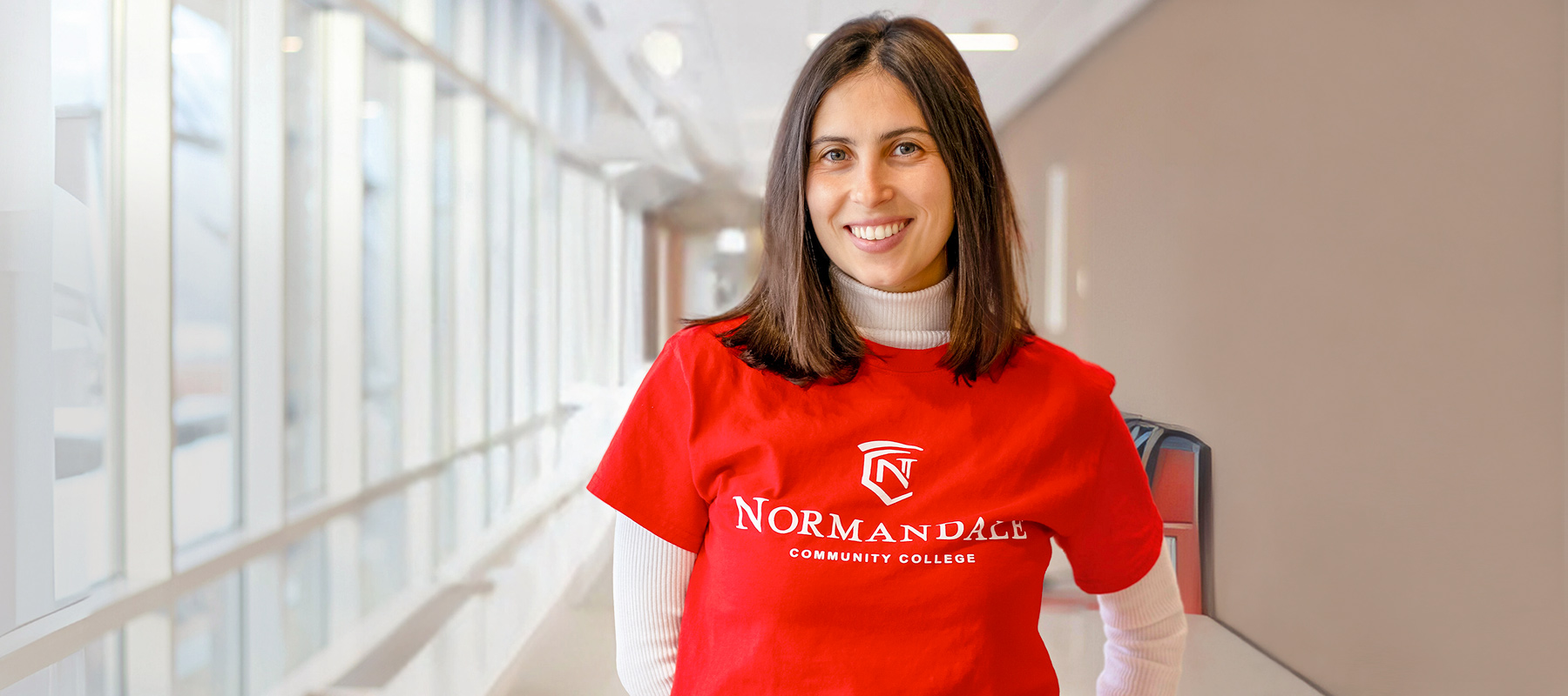 Happy Normandale student standing in a hallway