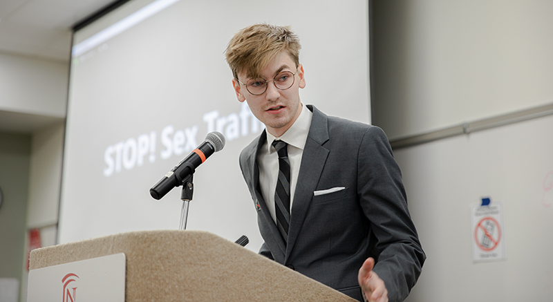 Image of male student speaking at a podium