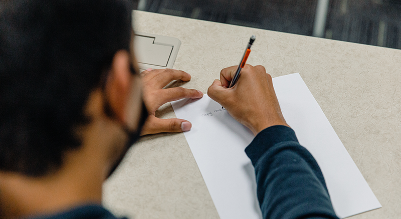 Student at Normandale writing on paper